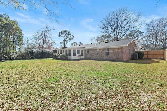 back of house featuring central air condition unit and a lawn