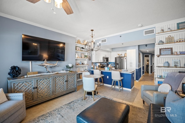 living room with light tile patterned floors, ornamental molding, visible vents, and ceiling fan with notable chandelier