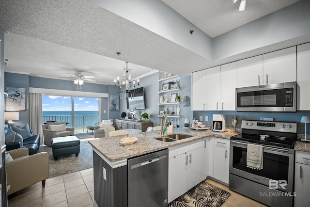 kitchen with a textured ceiling, stainless steel appliances, a peninsula, and a sink