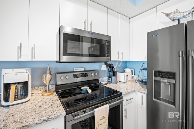 kitchen featuring light stone counters, white cabinets, and appliances with stainless steel finishes