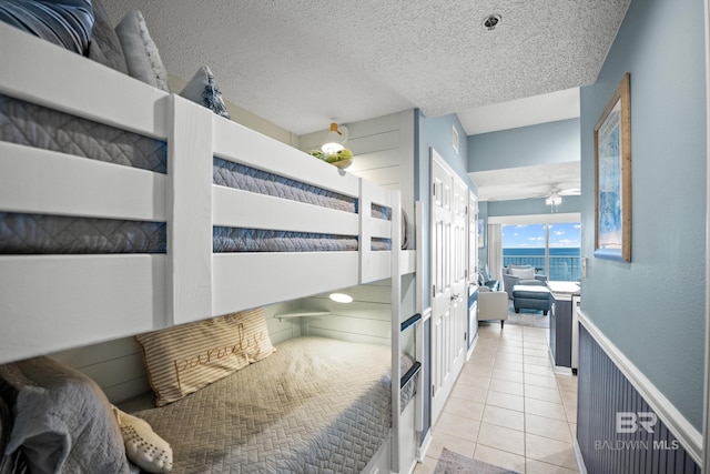 bedroom with a textured ceiling and tile patterned flooring