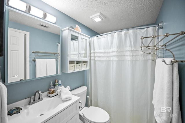 bathroom with vanity, a textured ceiling, a shower with shower curtain, and toilet