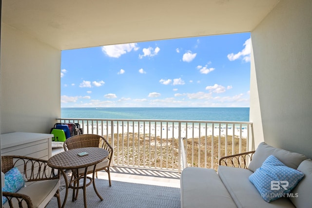 balcony featuring a water view and a beach view