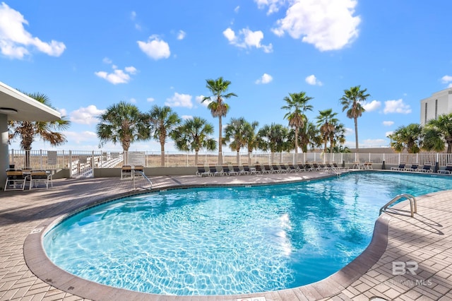 community pool featuring a patio and fence