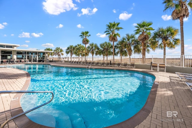 pool featuring fence and a patio area