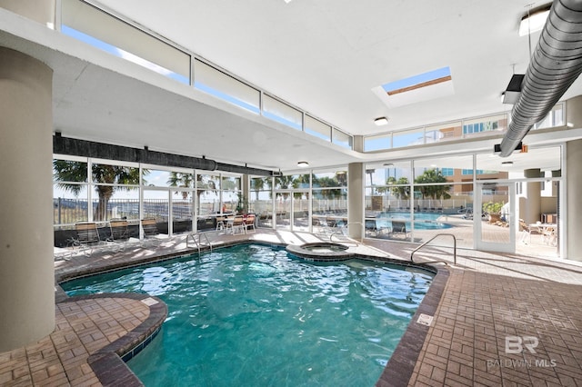 pool featuring an indoor hot tub, a patio, fence, and a lanai