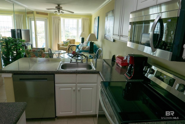 kitchen with ornamental molding, a peninsula, white cabinetry, stainless steel appliances, and a sink