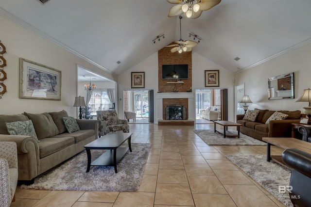 living room with ceiling fan with notable chandelier, crown molding, high vaulted ceiling, a fireplace, and light tile patterned flooring