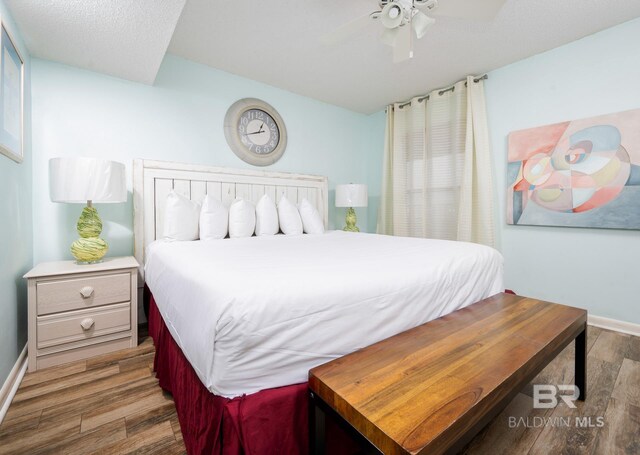 24132 Perdido Beach Blvd Unit 1024, Orange Beach, AL 36561 - bedroom featuring a ceiling fan, baseboards, and wood finished floors