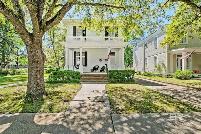 view of front of house with a balcony, a front yard, and a porch