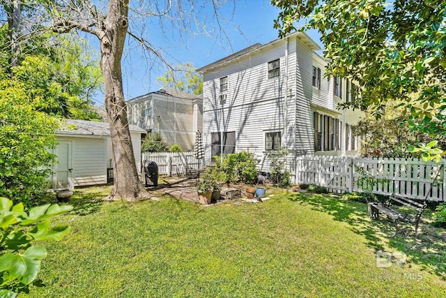 back of house with a yard and a storage unit