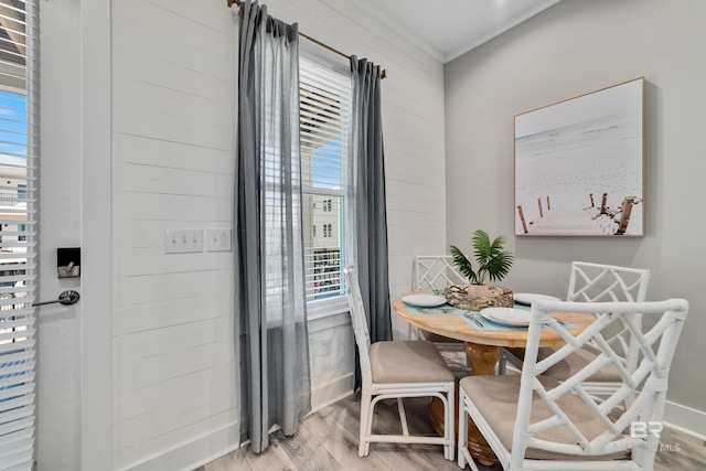 dining room with ornamental molding, baseboards, and light wood finished floors