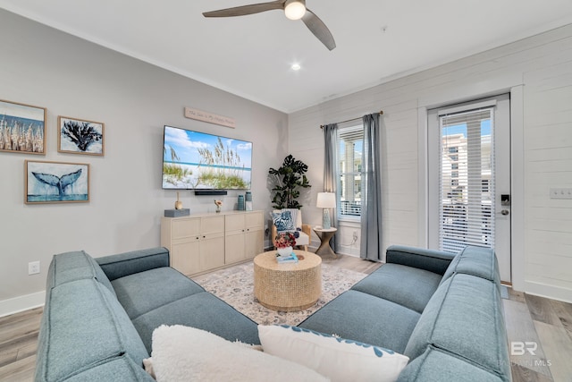 living room featuring recessed lighting, light wood-type flooring, a ceiling fan, and baseboards