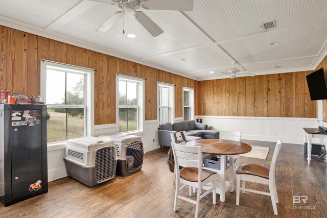 dining space featuring visible vents, a wainscoted wall, a ceiling fan, and hardwood / wood-style flooring
