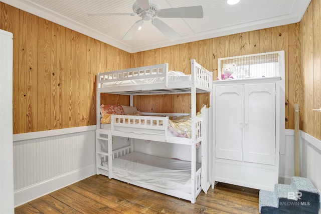 unfurnished bedroom featuring ceiling fan, wood finished floors, and wainscoting