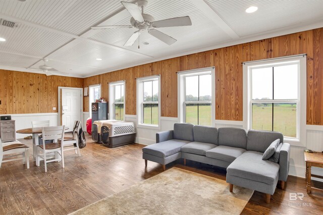 living room featuring radiator, a wainscoted wall, visible vents, ceiling fan, and wood-type flooring