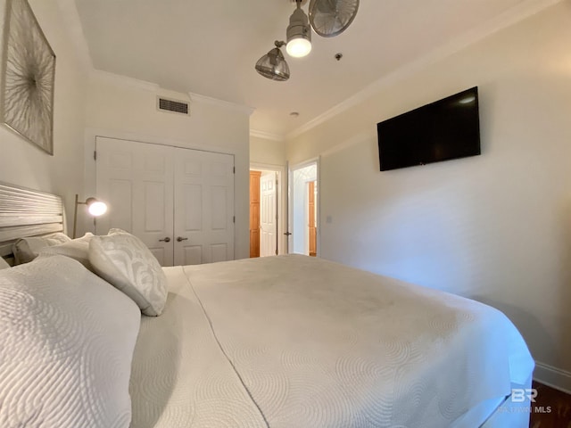 bedroom featuring ornamental molding, a closet, visible vents, and baseboards