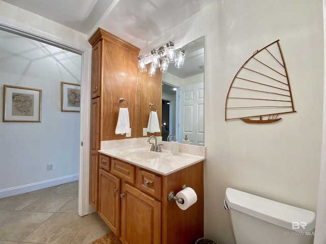 bathroom with baseboards, vanity, toilet, and tile patterned floors