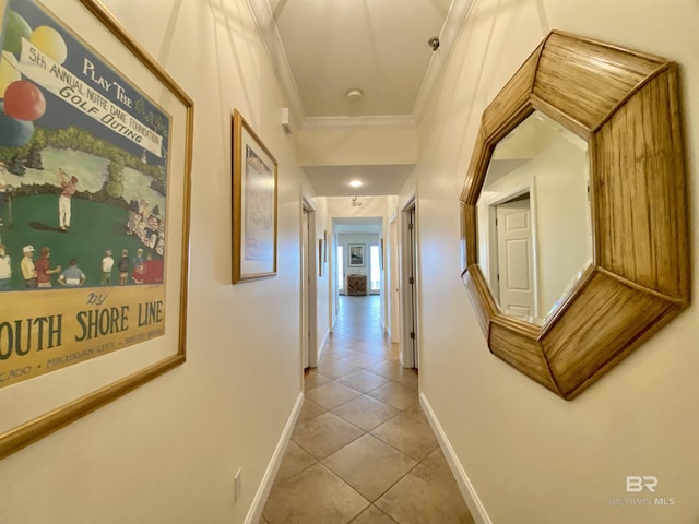 corridor with crown molding, baseboards, and light tile patterned floors