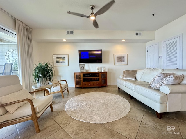 tiled living area featuring a ceiling fan, visible vents, and baseboards