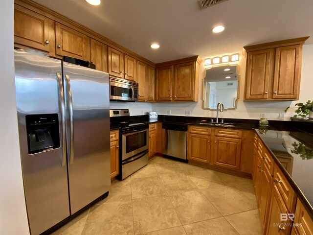 kitchen featuring brown cabinets, stainless steel appliances, a sink, and recessed lighting