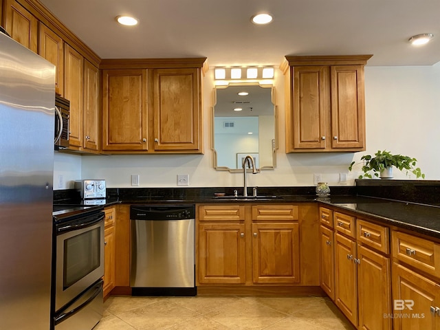 kitchen featuring brown cabinets, stainless steel appliances, and a sink