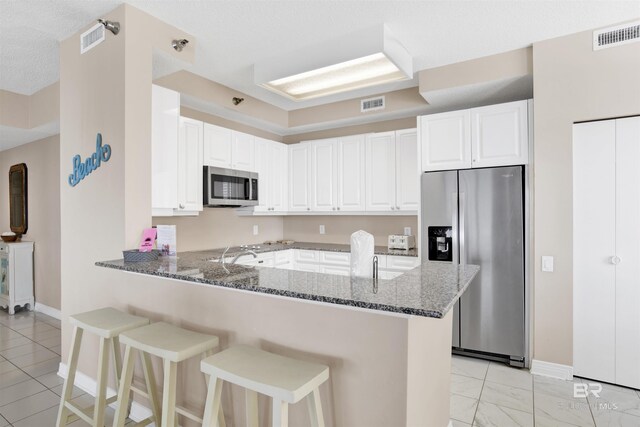 13601 Perdido Key Dr Unit W-12A, Perdido Key, FL 32507 - kitchen featuring a peninsula, dark stone counters, visible vents, and appliances with stainless steel finishes