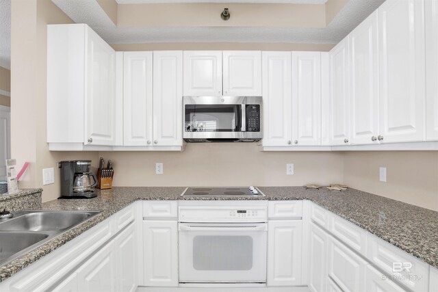 13601 Perdido Key Dr Unit W-12A, Perdido Key, FL 32507 - kitchen with black electric cooktop, a sink, stainless steel microwave, white oven, and white cabinetry