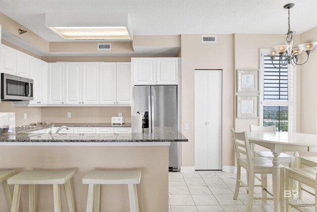 13601 Perdido Key Dr Unit W-12A, Perdido Key, FL 32507 - kitchen featuring dark stone countertops, marble finish floor, stainless steel appliances, a peninsula, and visible vents
