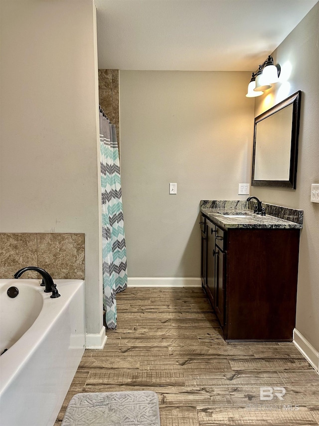 bathroom with hardwood / wood-style floors, a bathtub, and vanity