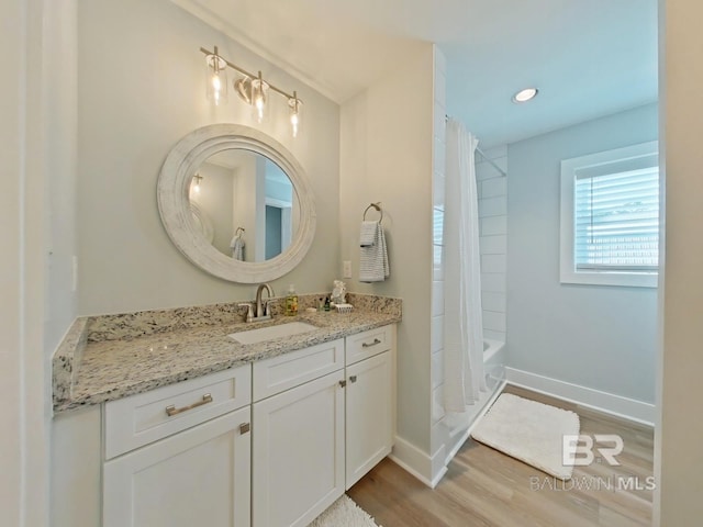 bathroom with vanity, wood-type flooring, and shower / bath combo with shower curtain