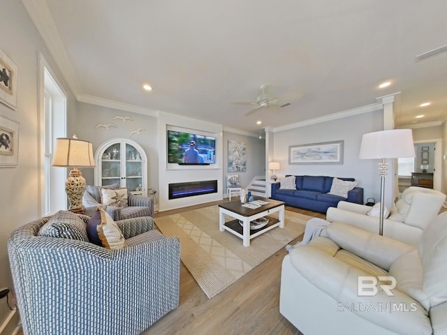 living room featuring crown molding, ceiling fan, and light hardwood / wood-style flooring