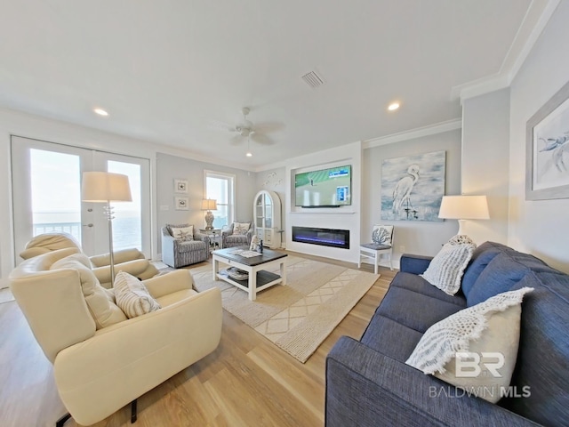 living room with crown molding, hardwood / wood-style floors, and ceiling fan