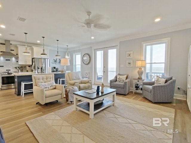 living room with french doors, ceiling fan, crown molding, and light hardwood / wood-style flooring