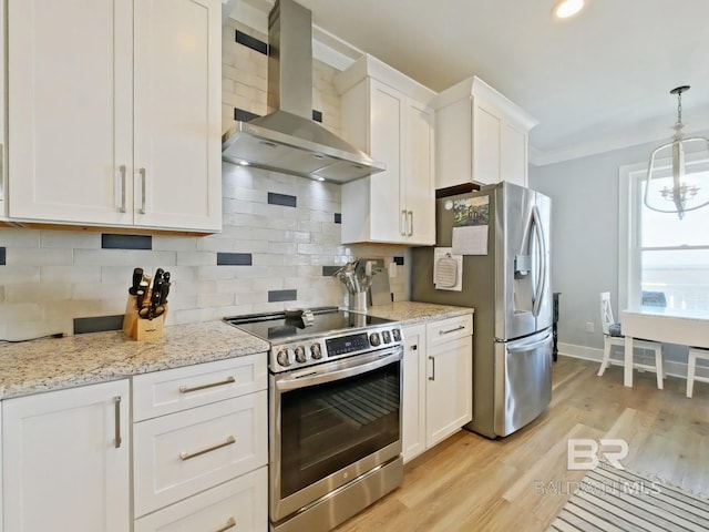 kitchen featuring appliances with stainless steel finishes, range hood, white cabinets, decorative backsplash, and hanging light fixtures