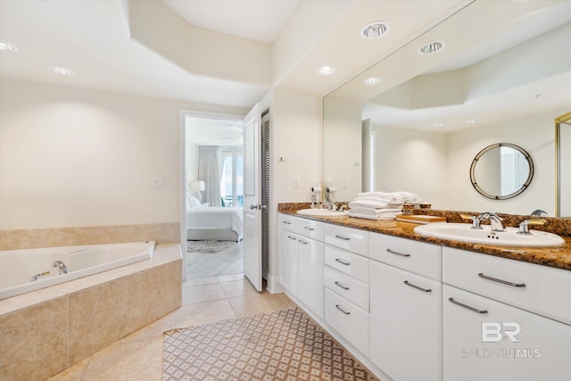 bathroom with vanity, tiled tub, and tile patterned flooring