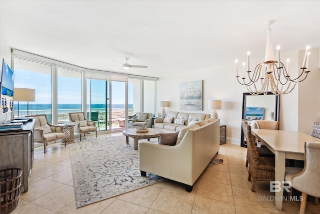 tiled living room featuring floor to ceiling windows, ceiling fan with notable chandelier, and a water view