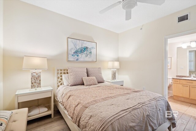 bedroom with connected bathroom, ceiling fan, light hardwood / wood-style flooring, and sink