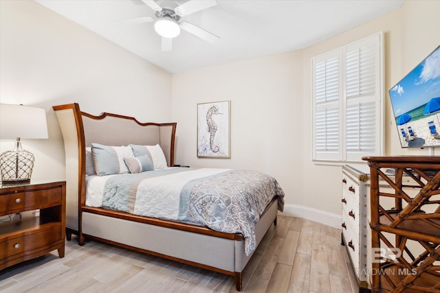 bedroom with ceiling fan, multiple windows, and light hardwood / wood-style flooring