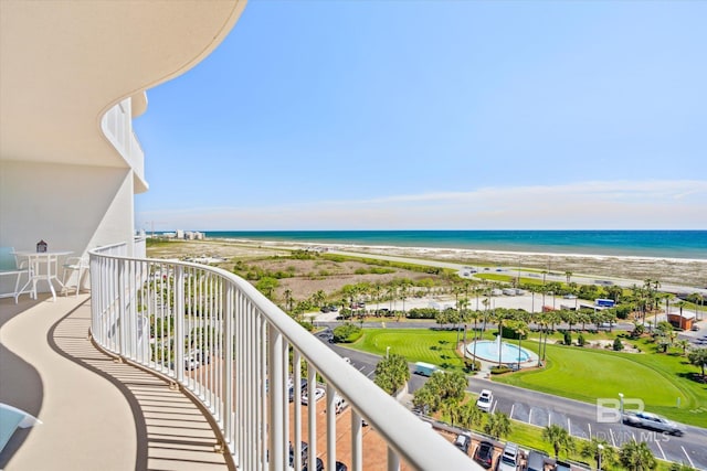 balcony featuring a water view and a beach view