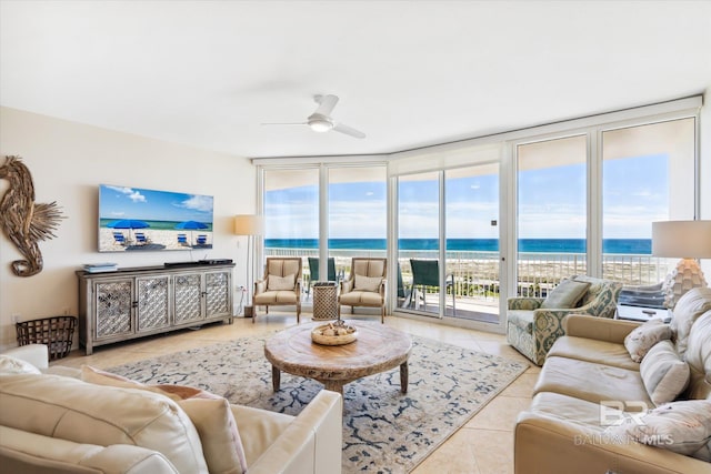 living room featuring a water view, light tile patterned floors, a wealth of natural light, and ceiling fan