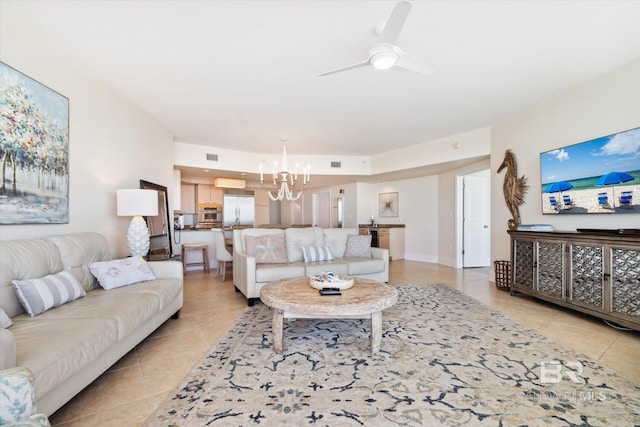 living room with ceiling fan with notable chandelier and light tile patterned floors