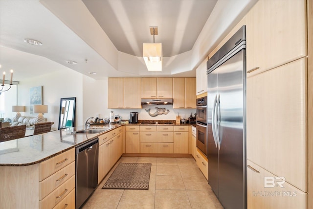 kitchen featuring light brown cabinetry, sink, kitchen peninsula, hanging light fixtures, and stainless steel appliances