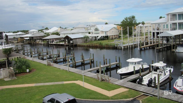 view of dock with a water view and a lawn