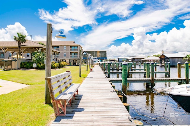 view of dock featuring a lawn and a water view