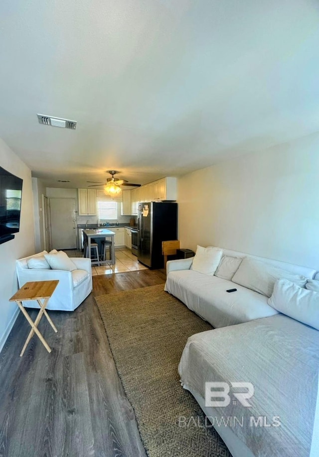 living room with ceiling fan and hardwood / wood-style flooring