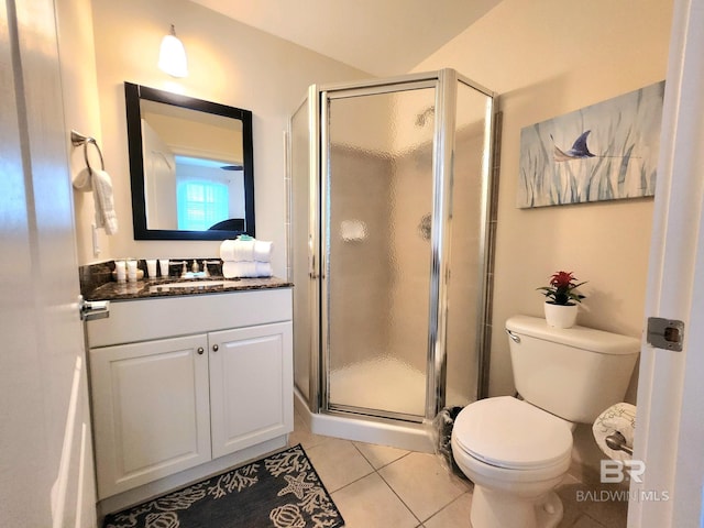 bathroom featuring tile patterned floors, vanity, toilet, and a shower with door