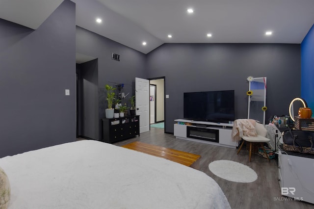 bedroom featuring recessed lighting, wood finished floors, and high vaulted ceiling