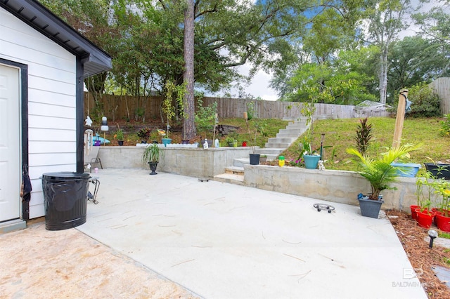 view of patio featuring a fenced backyard and stairway