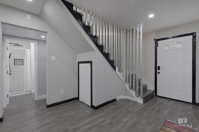 entryway with baseboards, wood finished floors, stairs, and recessed lighting